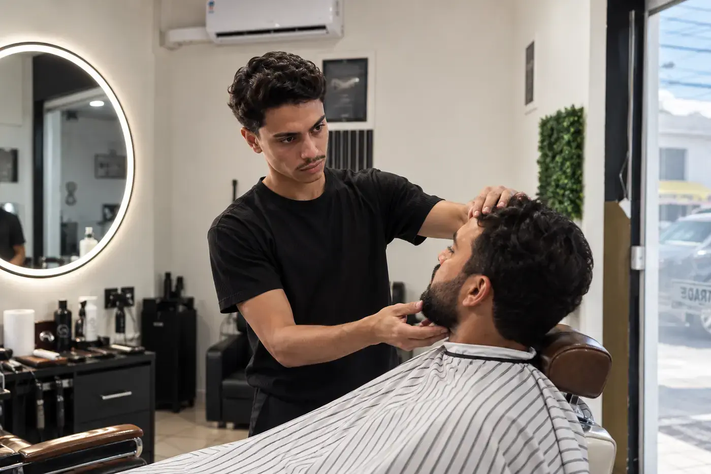 Regis analisa as proporções do rosto e da barba do cliente com as mãos